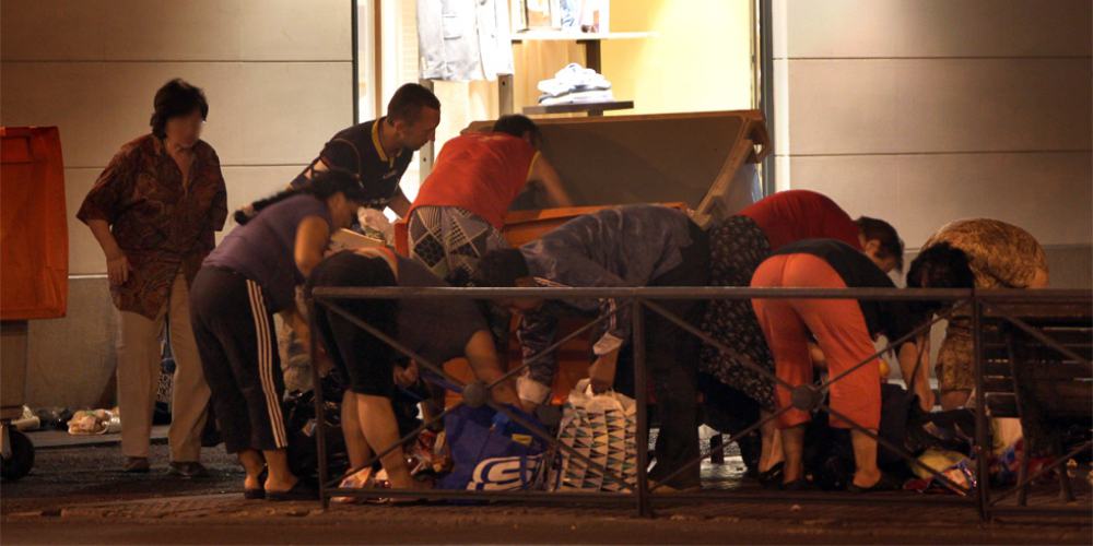 Población española recogiendo comida de la basura